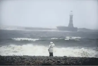  ??  ?? A walker braves the gusty conditions on Roker Beach.