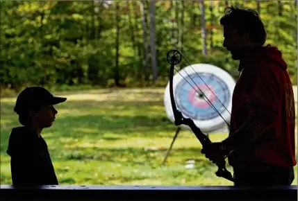  ?? Carolyn Kaster / Associated Press ?? A Boy Scout, left, works with an instructor on the archery field at Boy Scout camp at Camp Minsi in Pocono Summit, Pa. While summer camp costs are rising, parents can find deals by booking sessions early, asking about financial aid, and leveraging sibling and other discounts.