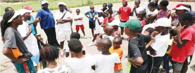  ??  ?? Wellington Sibanda (second from right) conducts tennis training at Emakhanden­i club in Bulawayo yesterday