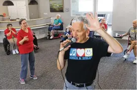  ?? REBECCA SLEZAK/DALLAS MORNING NEWS/TNS ?? Susan Norris dances as Eric Kolb, a founder of the nonprofit Songs & Smiles, spins while singing with residents on June 14 at Villagio of Carrollton in Carrollton, Texas. Those in attendance danced and sang along to popular 1960s-era songs. Kolb has visited the residents to sing twice a month over the last year.