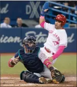  ?? Canadian Press photo ?? Toronto Blue Jays Devon Travis steals home beating the tag attempt by Seattle Mariners catcher Carlos Ruiz in the eighth inning of their AL baseball game in Toronto on Saturday.