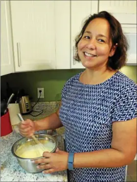  ?? PARIS WOLFE — THE NEWS-HERALD ?? Sonia Rodriguez of Concord Township mixes the egg mixture for flan.