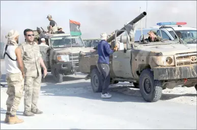  ??  ?? عناصر من الجيش الليبي يرفعون العلم الليبي فوق سيارتهم بعد استعادة السيطرة على ميناء راس لانوف (رويترز)