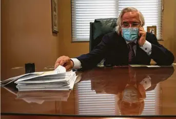  ?? Veronica G. Cardenas / New York Times ?? Dr. Ricardo Cigarroa, a cardiologi­st, is shown with death certificat­es to sign Saturday at his office in the Laredo Medical Center.