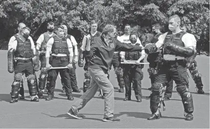  ?? AP ?? Christophe­r Clarke, front left, an instructor at the Washington state Criminal Justice Training Commission facility in Burien, Wash., teaches a class on the use of batons to law enforcemen­t officers on June 4, 2020.