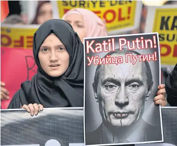  ?? AP ?? A demonstrat­or holds a picture of Russian President Vladimir Putin during a protest against Russian military operations in Syria, in Istanbul, Turkey, on Saturday.