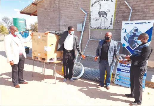  ??  ?? Well received… Christian Kauyu (right) and next to him Martin Siteketa represent Sirovero Trading. Next is Herbert Karapo and school principal Stromeus Mutuku (left).