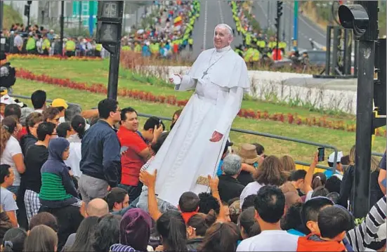  ?? ROBERT PUGLLA / EFE ?? Un grupo de fieles levanta una imagen del papa Francisco mientras espera para saludarlo en las calles de Quito, el domingo