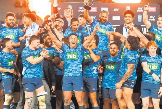  ?? Photo / Photosport ?? The Blues celebrate their first Super Rugby title in 18 years after their 23-15 win over the Highlander­s on Saturday night at Eden Park.