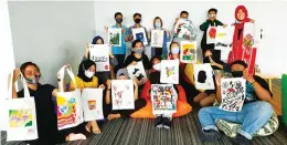  ?? FITRI ART FOR JAWA POS ?? BERAGAM: Para peserta melukis bersama menunjukka­n hasil karya lukis pada tote bag.