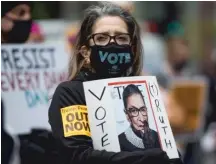  ??  ?? Ruth Novak holds a sign with the late Supreme Court Justice Ruth Bader Ginsburg’s picture during the Women’s March.