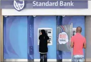  ?? PHOTO: REUTERS ?? Customers outside an ATM at a Standard Bank branch in Cape Town. No evidence of collusion was provided.