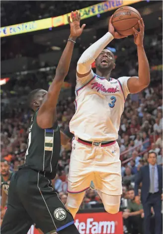  ?? TNS ?? The Heat's Dwyane Wade goes to the basket against the Bucks’ Tony Snell on Friday night. Wade had three points and two assists in his return to Miami.