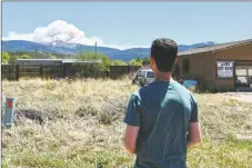  ?? GEOFFREY PLANT/Taos News ?? Matt Pacheco watches from Peñasco as smoke clouds from the Calf Canyon-Hermits Peak Fire accumulate behind Jicarita Peak on Friday (May 13). Holy Cross Medical Center announced over the weekend that it is evaluating its air filtration system in readiness for possible air quality degradatio­n from several wildfires burning in Northern New Mexico.