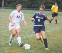  ?? STAFF PHOTO BY MICHAEL REID ?? McDonough’s Kennedy Bradshaw, left, and La Plata’s Alex Falenofoa race toward a loose ball in Monday night’s game at McDonough. Falenfoa scored the game-winning goal in the first minute of the second overtime to give the Warriors a 3-2 win.