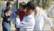  ?? ASSOCIATED PRESS ?? Men carry children away from an explosion site in Lashkar Gah, Afghanista­n, on Saturday after a suicide bombing attack, one of several reported.