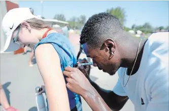  ?? JUSTIN TANG THE CANADIAN PRESS ?? Sprinter Aaron Brown signs a volunteer’s shirt Thursday at the Canadian track and field championsh­ips.