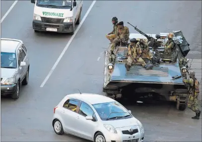  ?? Tsvangiray­i Mukwazhi ?? The Associated Press Soldiers man their position with a military vehicle outside the office of President Robert Mugabe, Wednesday in Harare, Zimbabwe. Zimbabwe’s military controls the capital and the state broadcaste­r and is holding Mugabe and his wife...