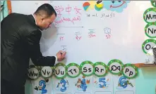  ?? XINHUA Center: ?? Left: A Yemeni instructor teaches students Chinese in the capital Sanaa last year.