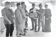  ??  ?? (Gambar atas) HAJI YUNUS Abd Raja menaja pembelian Album Raya Kita Bah.
(Gambar bawah) ADIN HANS (badut dan artis) merakam gambar bersama Apiz Pachya dan tetamu yang lain.