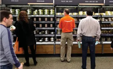  ?? MIKE KANE/BLOOMBERG ?? The Amazon Go store offers ready-to-eat meals, snacks and grocery staples such as bread, milk and cheese.