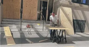  ?? PROVIDED ?? Wilson Gonzalez, founder of A Quality Board-Up & Emergency Services, installs plywood Tuesday at Chicago’s Blackstone Hotel to prevent damage.