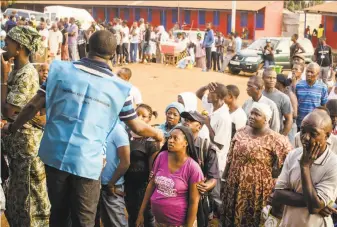  ?? Cooper Inveen / Associated Press ?? Sierra Leone voters wait in line to cast their ballots outside a polling station in the capital city, Freetown. The presidenti­al field was crowded with 16 candidates.