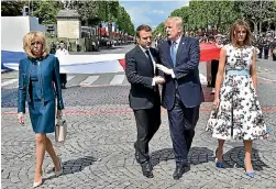  ?? POOL ?? Fashion contrasts: The presidents’ wives - Brigitte Macron, left, and Melania Trump.
