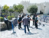  ?? (Amir Cohen/Reuters) ?? POLICE CHECK a Palestinia­n on his way to the Damascus Gate entrance to the capital’s Old City on Friday.