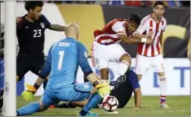  ?? MATT ROURKE — THE ASSOCIATED PRESS ?? U.S. goalkeeper Brad Guzan (1) stops the ball kicked by Paraguay’s Jorge Benitez (7) as the U.S.’s Fabian Johnson (23) and Paraguay’s Miguel Almiron (17) look on late in a Copa America Group A soccer match Saturday. Team USA won 1-nil to advance to the...