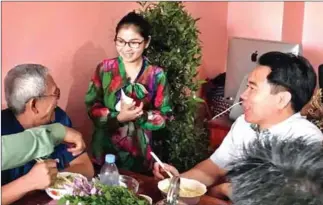  ?? FACEBOOK ?? Former CNRP Commune Chief Sin Rozeth (centre) speaks to customers at her restaurant in Battambang, which she started following the party’s dissolutio­n in November.