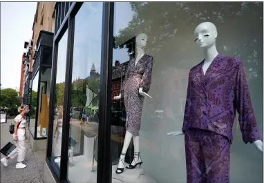  ?? (AP/Steven Senne) ?? A shopper enters a clothing store Tuesday in Boston’s Newbury Street shopping district. Consumer sentiment increased in early September to a six-month high, according to a report from the University of Michigan.