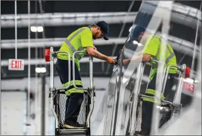  ?? (The Washington Post/Heather Ainsworth) ?? Alstom employee Caleb Alger replaces a gasket under the lights of a train.