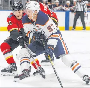  ?? CP PHOTO ?? Calgary Flames defenceman Rasmus Andersson (54) battles for the puck with Edmonton Oilers forward Connor McDavid (97) during second period NHL preseason action in Edmonton on Monday.