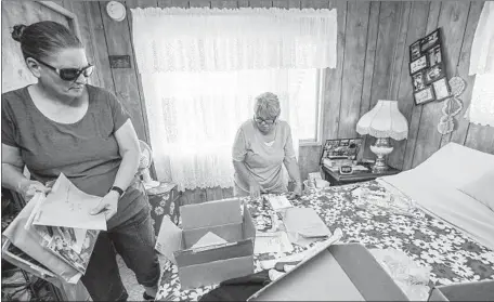  ?? Irfan Khan Los Angeles Times ?? SUSAN MANSON, left, helps her mother, Charlotte Sturgeon, save photos and documents from a red-tagged mobile home in Ridgecrest.