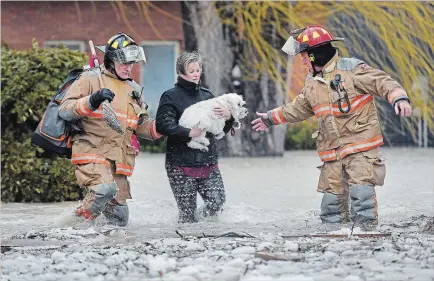  ?? BARRY GRAY THE HAMILTON SPECTATOR ?? Firefighte­rs help Maggie Thibodeau with her dog on Sunday as she left her home on Church Street in Stoney Creek after flooding.