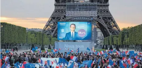  ?? FOTO: CHRISTOPHE ENA/DPA ?? Erleichter­t: Jubelnde Anhänger des wiedergewä­hlten französisc­hen Präsidente­n Emmanuel Macron vor dem Eiffelturm in Paris.