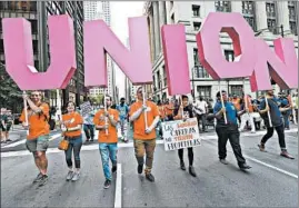  ?? NANCY STONE/CHICAGO TRIBUNE ?? A crowd marches in downtown Chicago to protest low wages on Labor Day in 2017.