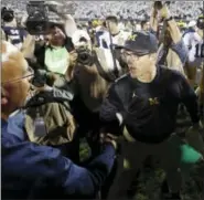  ?? CHRIS KNIGHT — THE ASSOCIATED PRESS ?? Michigan coach Jim Harbaugh, right, shakes hands with Penn State coach James Franklin at the end of an NCAA college football game in State College, Pa., Saturday. Penn State won 42-13.