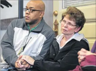  ?? THE ENQUIRER ?? Sue Braun, wife of Cincinnati Fire Chief Richard Braun, clasps hands with a firefighte­r from Station 32 in Avondale Thursday during the press conference about the death of Cincinnati firefighte­r Daryl Gordon. Gordon, 54, died after falling down an elevator shaft while searching for people in a building fire.