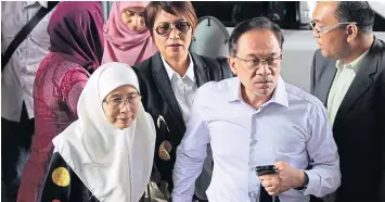  ?? REUTERS ?? Malaysia’s opposition leader Anwar Ibrahim, second left, arrives with his wife Wan Azizah, left, for the verdict in his final appeal against a conviction for sodomy, at the federal court in Putrajaya, yesterday.