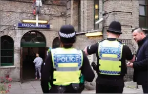  ?? The Associated Press ?? Police forces guard a subway entrance following Friday’s incident on a tube at Parsons Green Station in London, Sunday. A manhunt is under way after an improvised explosive device was detonated on a crowded subway car, injuring at least 29 people.