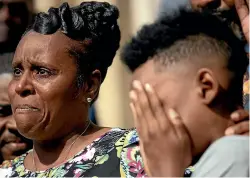  ?? AP ?? Tirzah Patterson, former wife of Buffalo shooting victim Heyward Patterson, speaks as her son, Jaques ‘‘Jake’’ Patterson, 12, covers his face during a press conference outside the Antioch Baptist Church yesterday in Buffalo, NY.