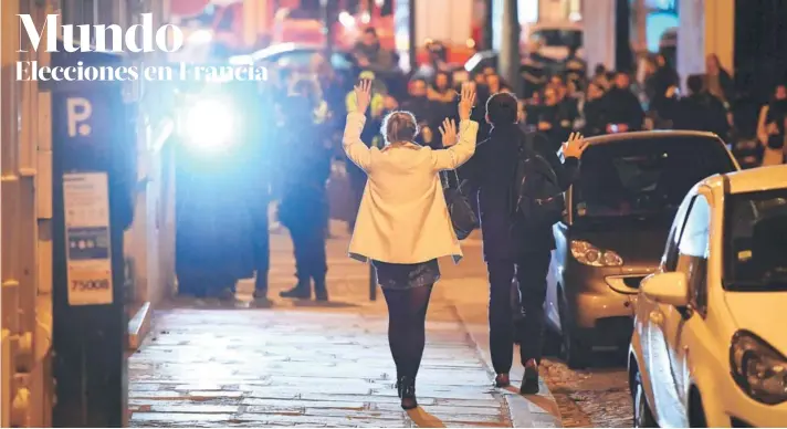  ?? FOTO: AFP ?? ►► Dos personas caminan con sus manos en alto por orden de la policía, en la zona del ataque de anoche en París.