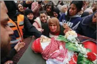  ?? (AFP) ?? The mother of Omar Khmour, 14, mourns over his body during his funeral in Bethlehem’s Dheisheh refugee camp in the occupied West Bank on Monday.