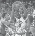  ??  ?? Grand Canyon 's Oscar Frayer pulls down a rebound against Jacksonvil­le's Tyreese Davis (23) and Aamahne Santos on Monday.