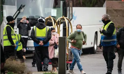  ?? Photograph: Dominic Lipinski/PA ?? Security staff escort passengers as they arrive at a hotel near Heathrow airport, London, to begin a 10-day quarantine period after returning to England from one of 33 ‘red list’ countries.