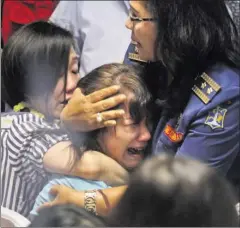  ??  ?? Pårørende til de 162 personer, som var med på fly 8501 fra AirAsia, sørger, imens de venter på svar på, hvad der er sket med deres kære.