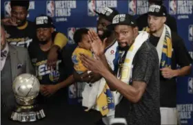  ?? DAVID J. PHILLIP — THE ASSOCIATED PRESS ?? Kevin Durant celebrates with teammates as they receive their trophy after defeating the Rockets in Game 7 of the Western Conference finals on May 28 in Houston.