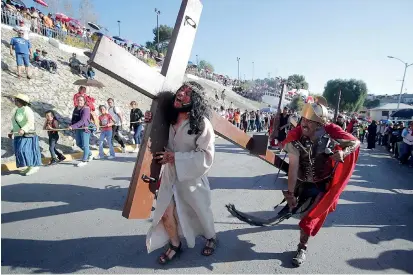  ?? ?? Los fieles siguieron paso a paso el dolor de Cristo al cargar la pesada cruz de 25 kilos.